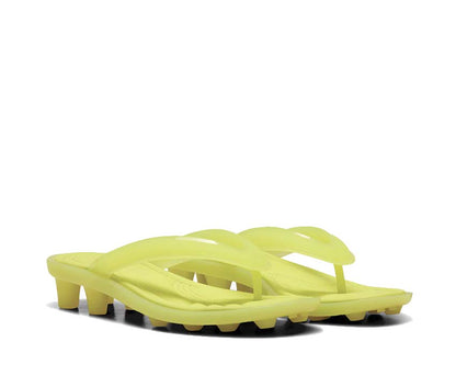 Scarpa sportiva con tacchetti in materiale trasparente e design contemporaneo.