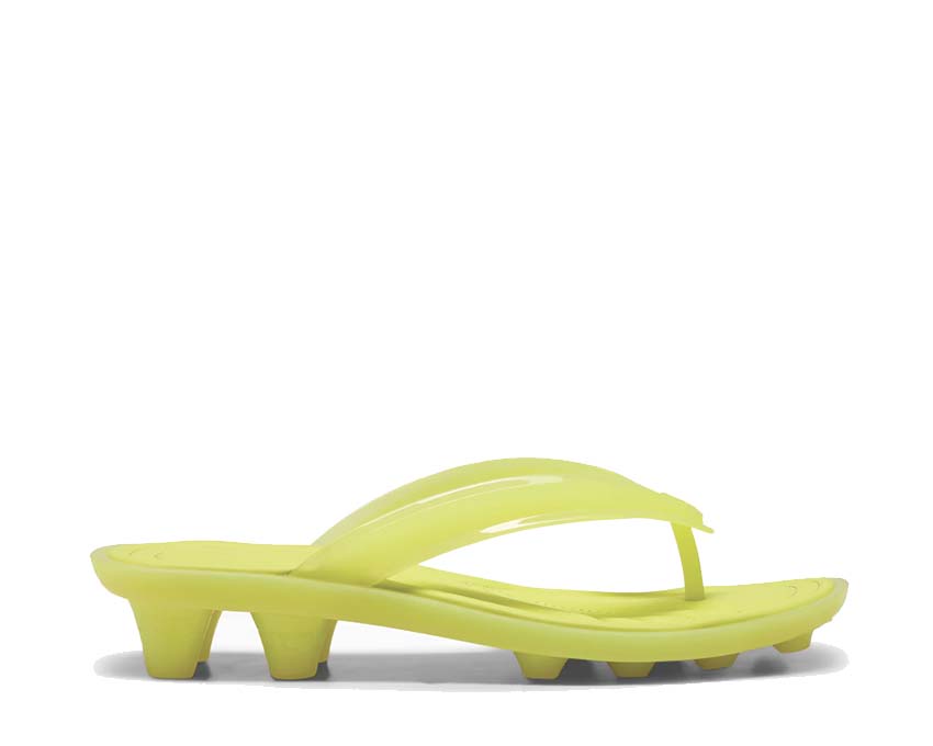 Scarpa sportiva con tacchetti in materiale trasparente e design contemporaneo.